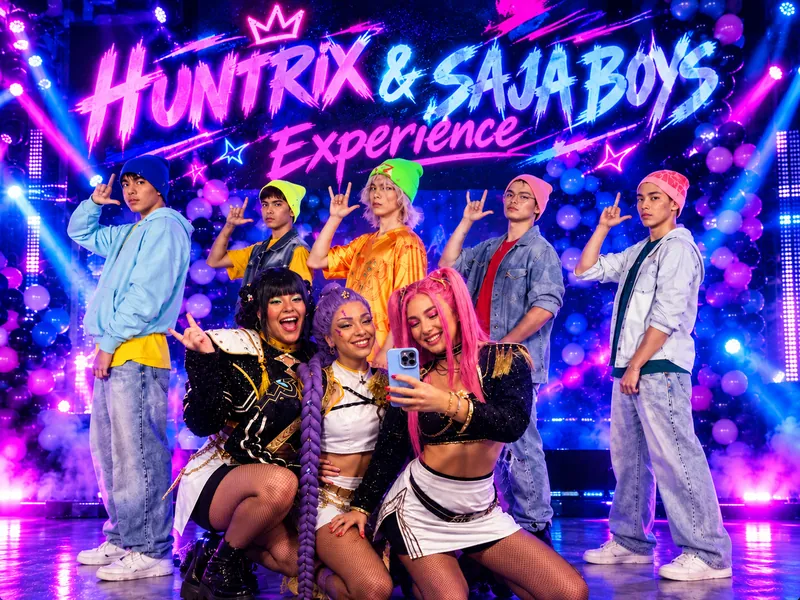 Huntrix & Saja Boys Experience: χορευτές σε σκηνή με neon φωτισμό