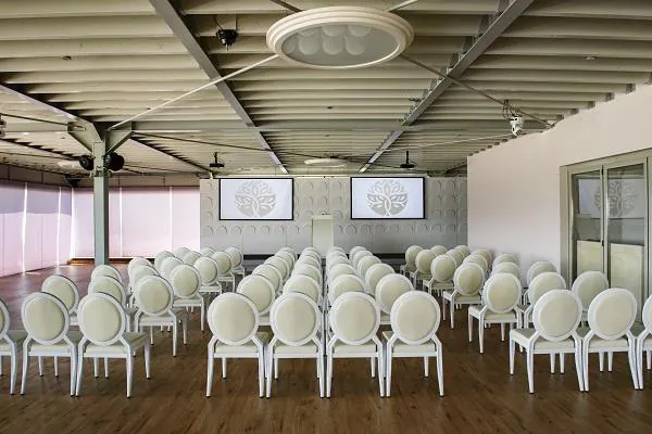 Φωτεινή αίθουσα loft με θεατρική διάταξη καθισμάτων για παρουσίαση